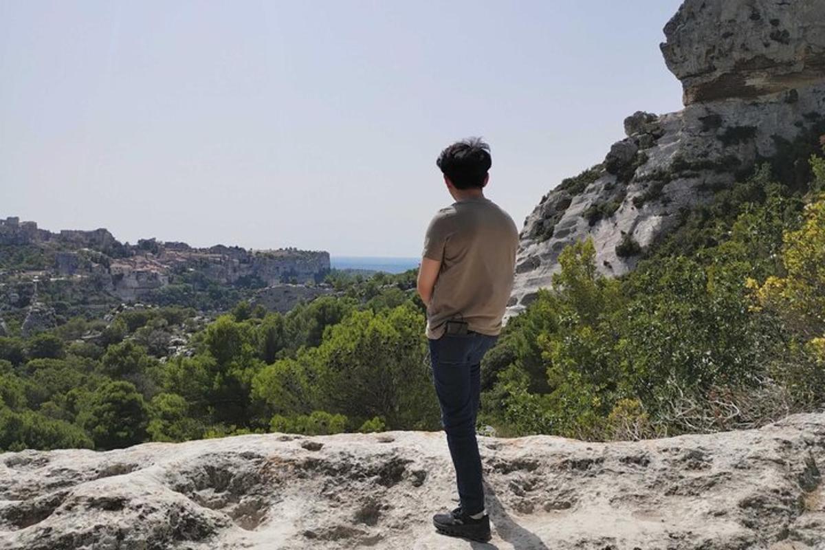 ένας άντρας που στέκεται πάνω σε έναν βράχο κοιτάζοντας τη θέα