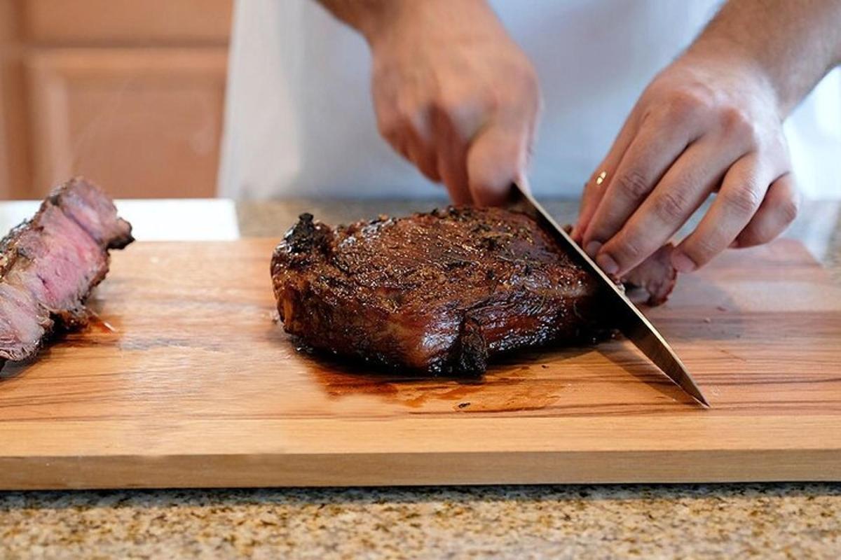 maður sem sker steik á skurðarbretti með hníf