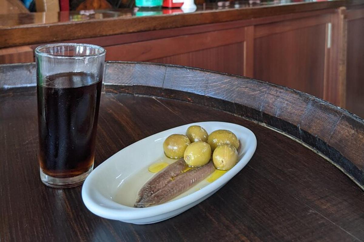 ένα πιάτο ελιές και ένα ποτήρι αναψυκτικό