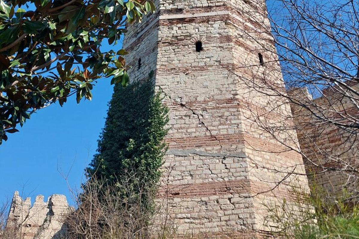 ein hoher Backsteinturm mit Efeu darauf
