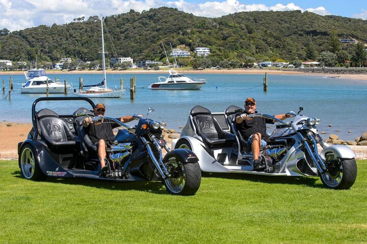 two men sitting on motorcycles with a side car