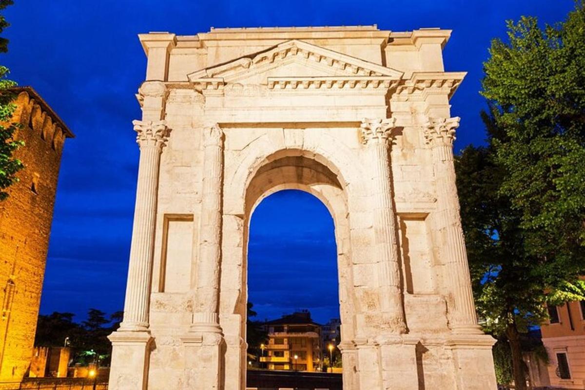 μια μεγάλη πέτρινη αψίδα σε μια πόλη τη νύχτα