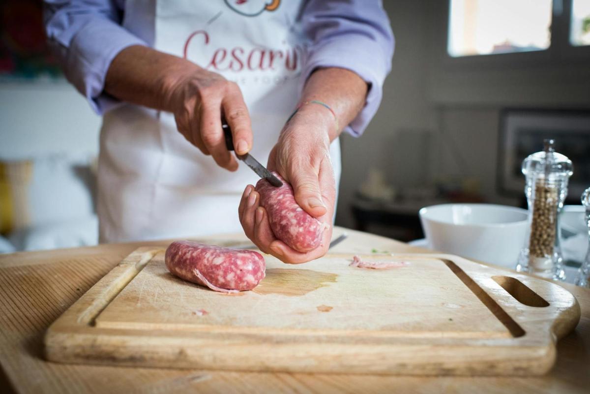 eine Person, die ein Stück Fleisch auf einem Schneidebrett zerschneidet