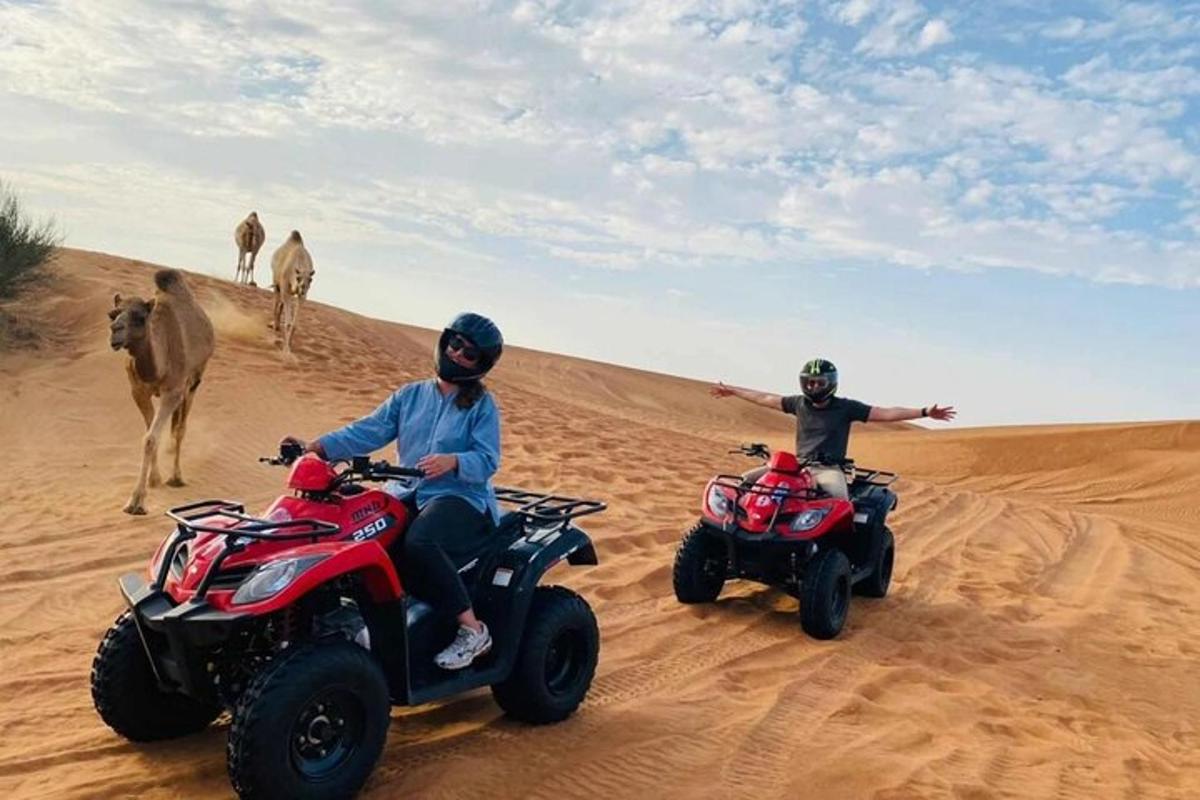 two people riding atvs in the desert with a camel