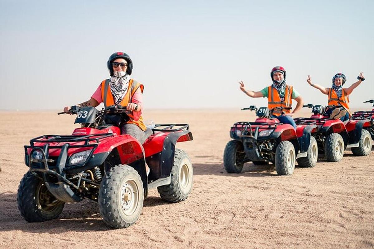 sekumpulan orang menunggang atv di padang pasir