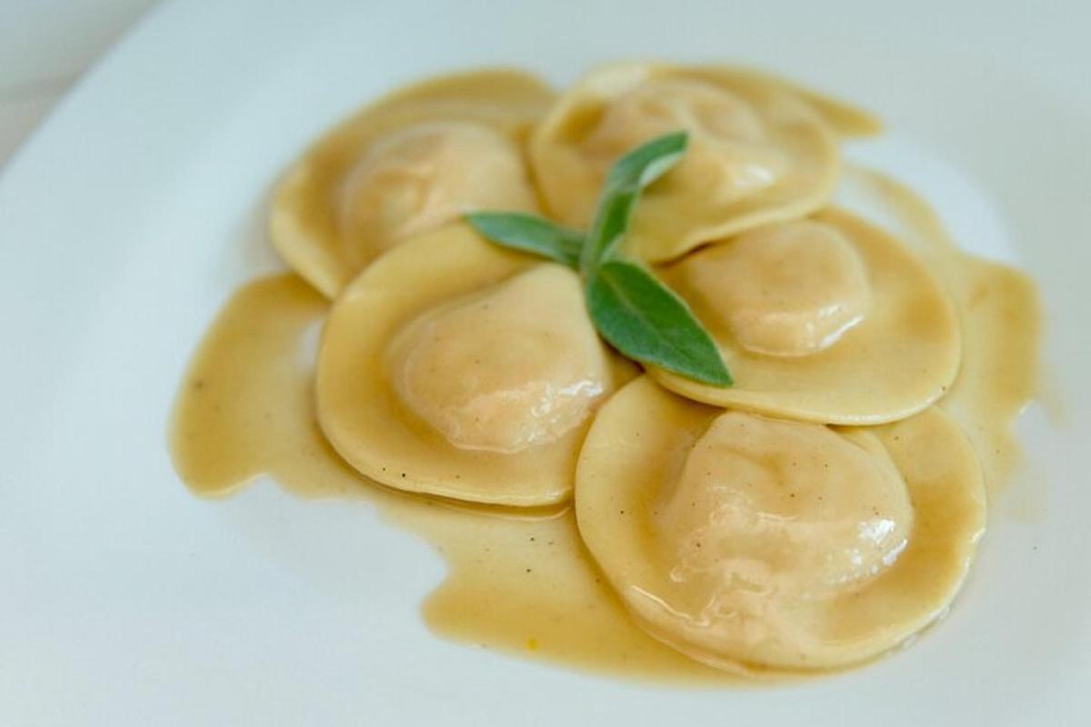un piatto di ravioli con una foglia verde sopra