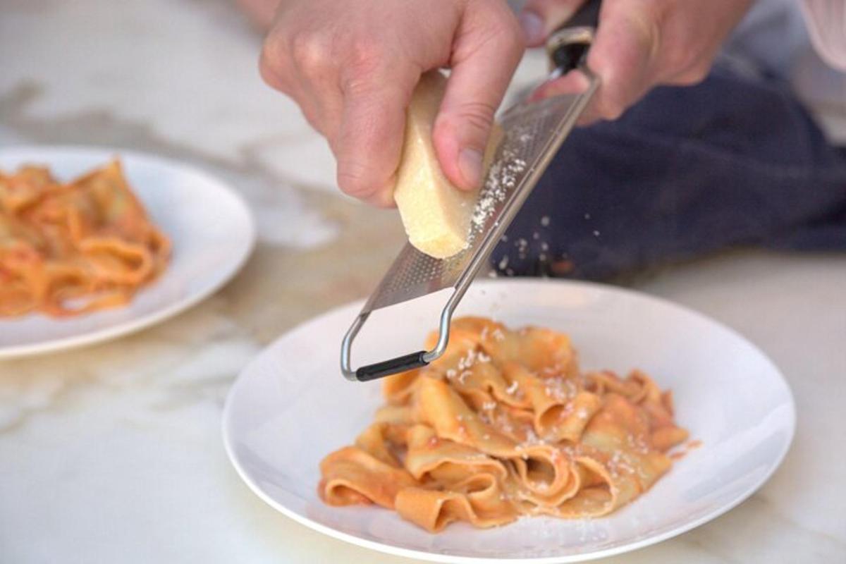 una persona sta mangiando la pasta con una forchetta e un coltello
