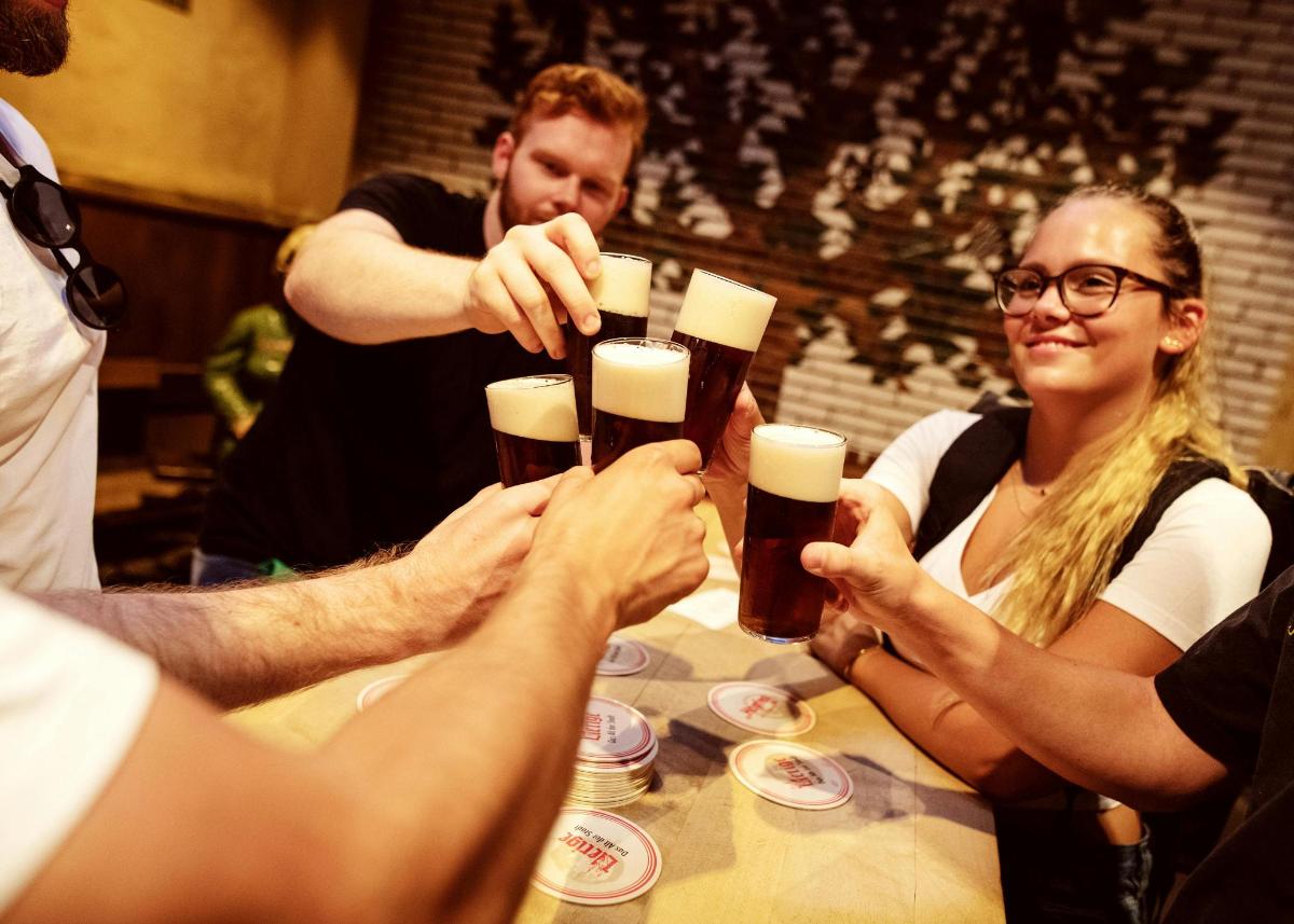 テーブルの周りに座ってビールを飲んでいる人々のグループ