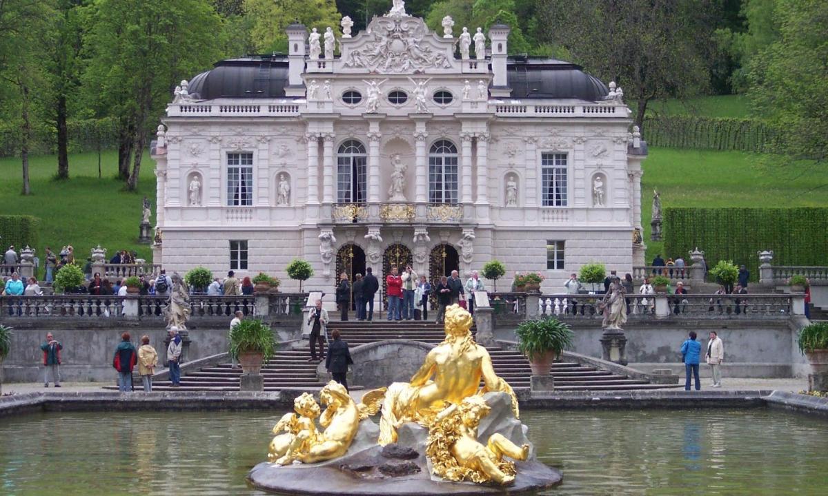 a building with a statue in the water in front