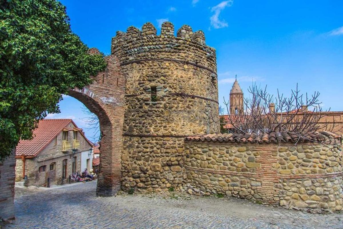 starý kamenný múr s oblúkom a budovou