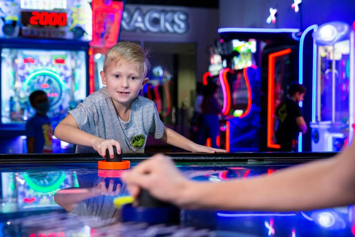 um menino jogando pinball
