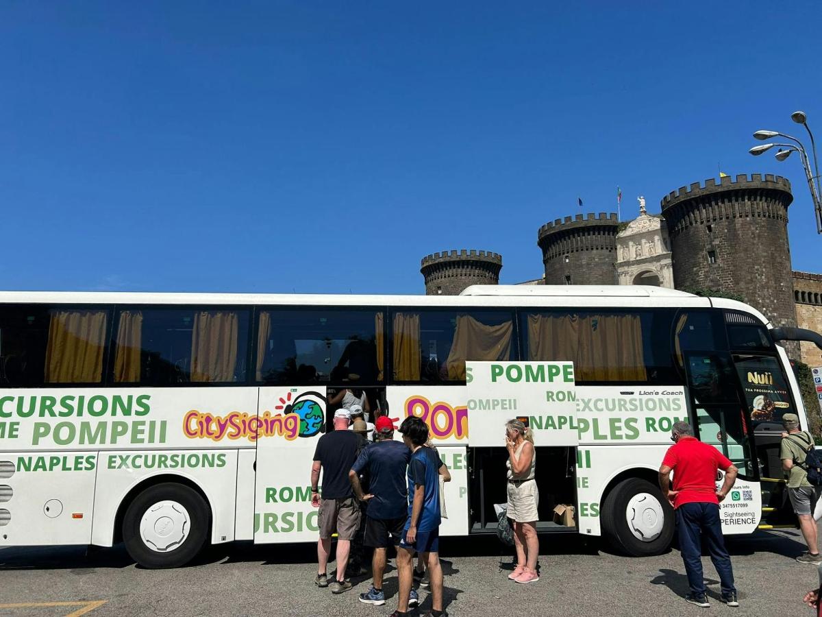um grupo de pessoas em pé na frente de um ônibus