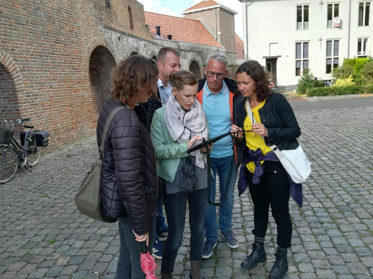a group of people standing around looking at a map