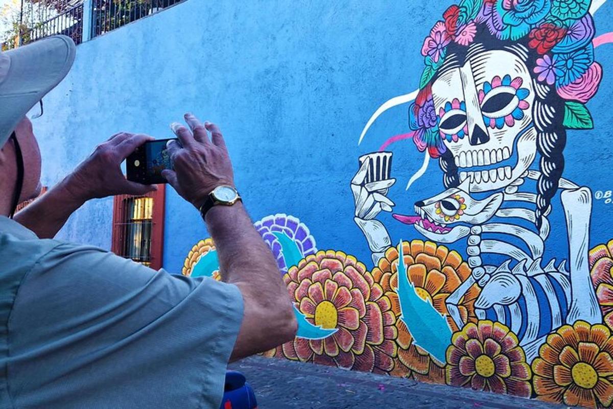 a man taking a picture of a mural of a skeleton