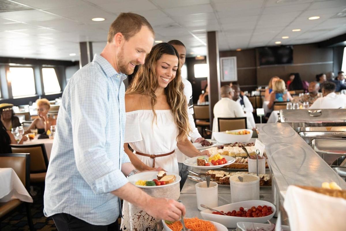 a man and a woman preparing food at a buffet