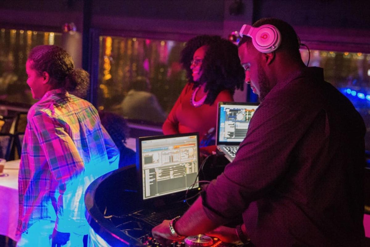 a group of people sitting at a bar with their computers