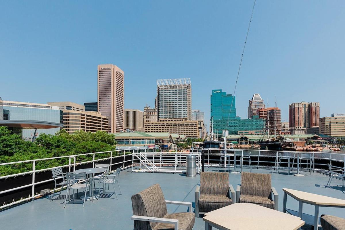 a balcony with tables and chairs and a city skyline