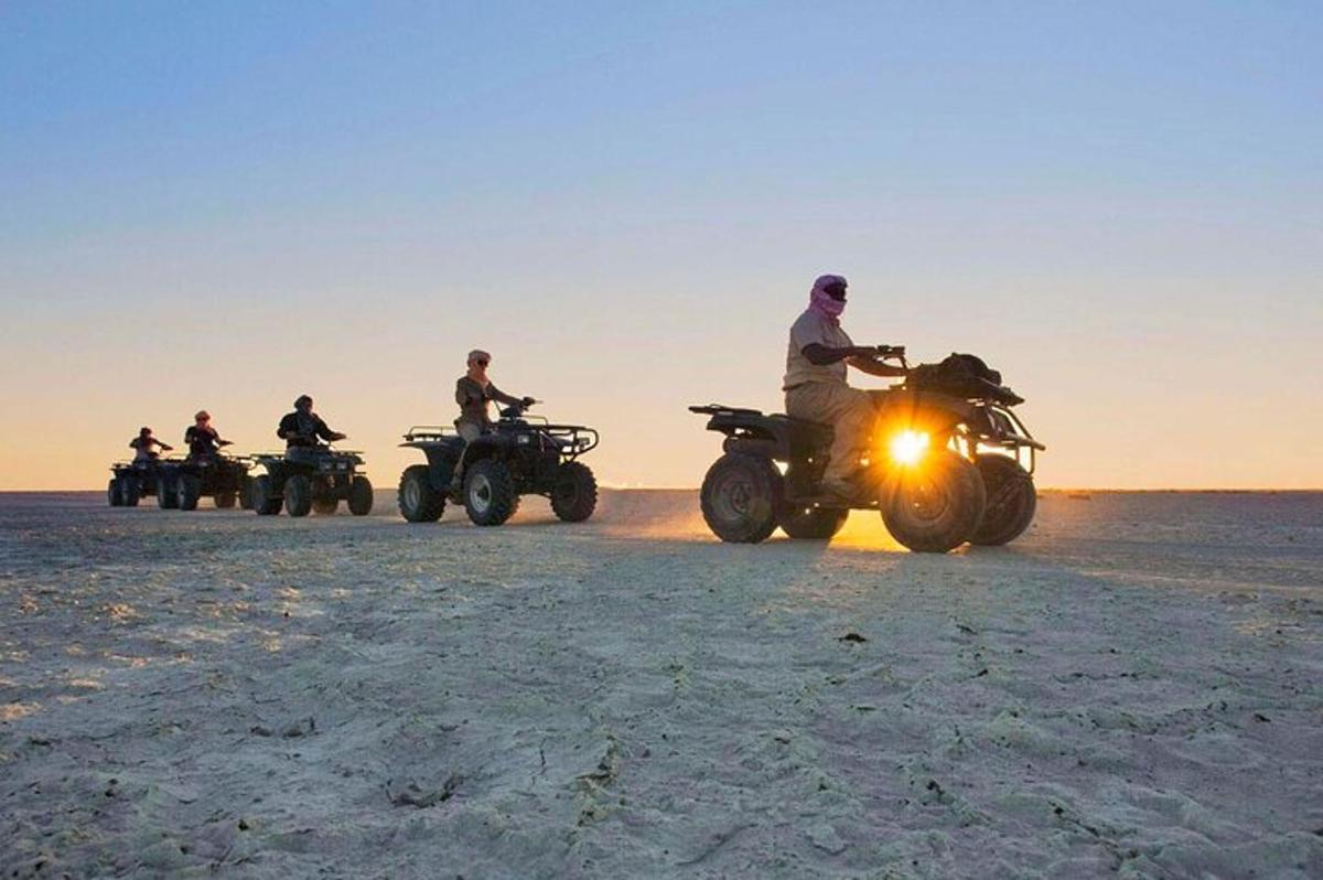 Un grupo de personas conduciendo vehículos todo terreno en la playa.