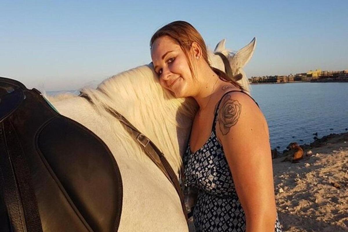 o femeie care stă pe plajă cu o placă de surf