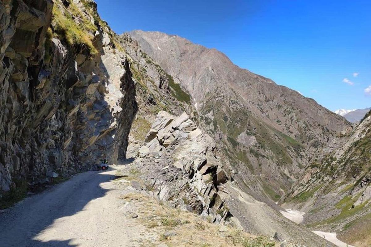 a dirt road on a mountain side with a rocky slope