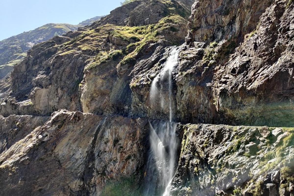 a waterfall on the side of a rocky mountain