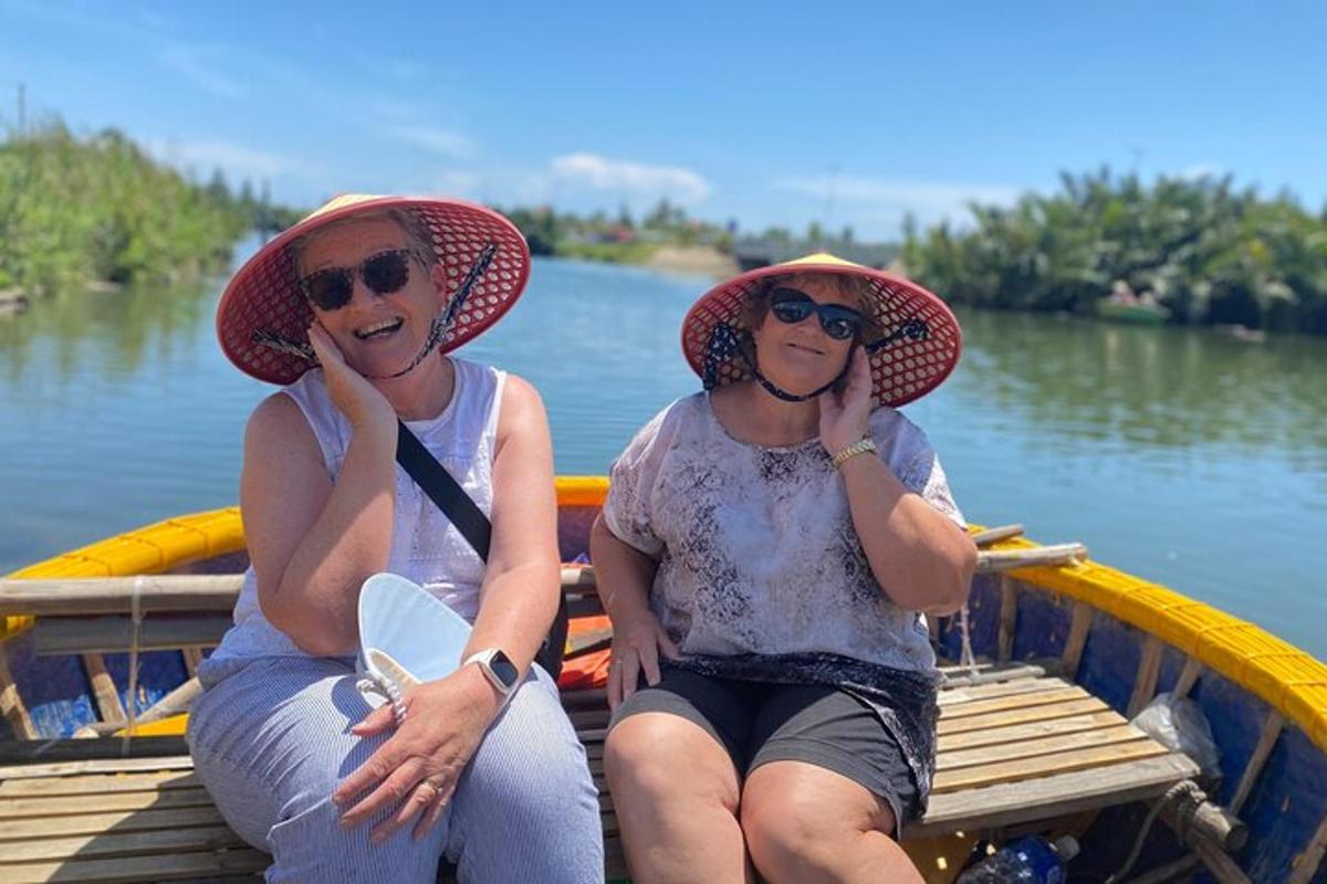 due donne con cappelli sedute su una barca sull'acqua
