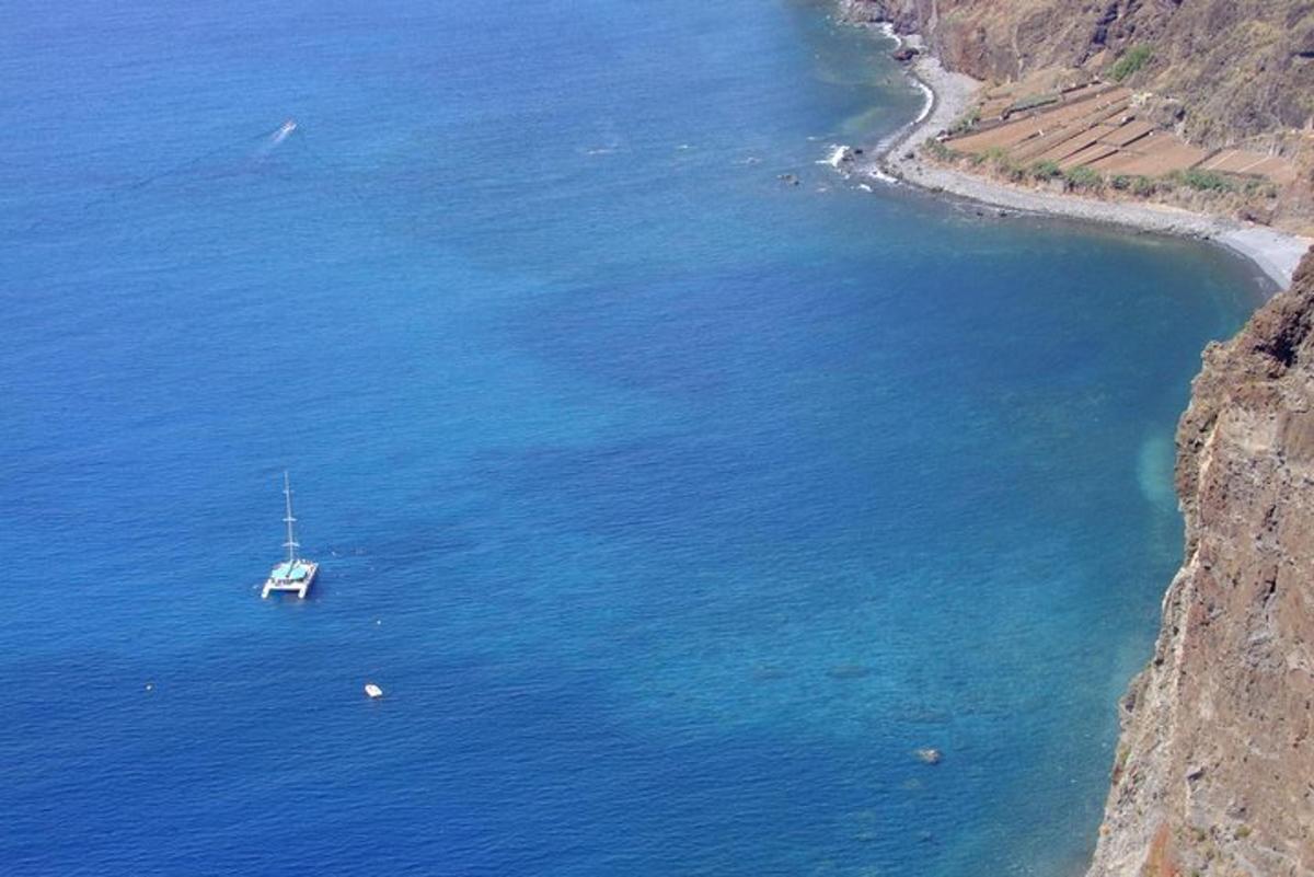 一艘船漂浮在悬崖边的海面上