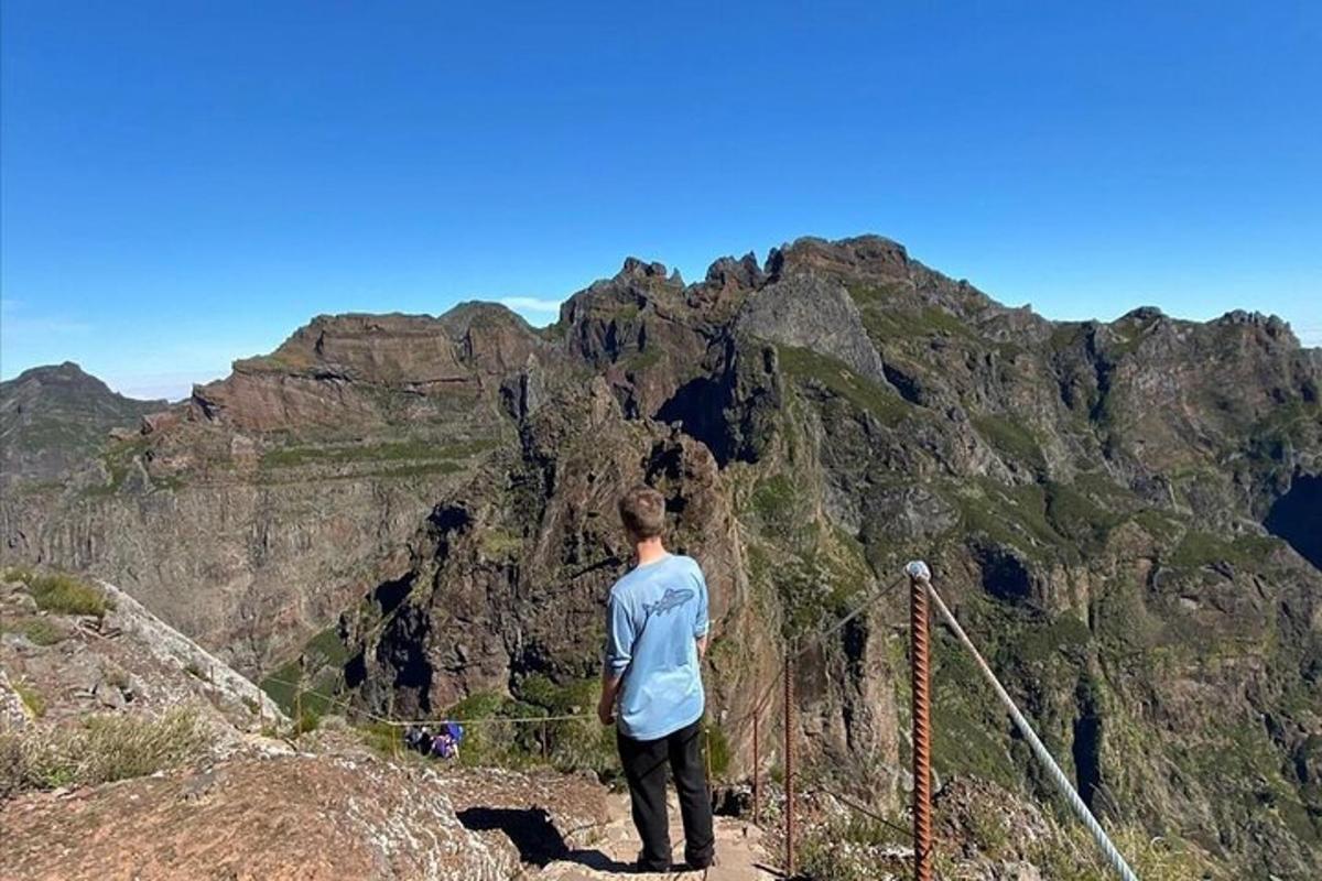 um homem em pé no topo de uma montanha