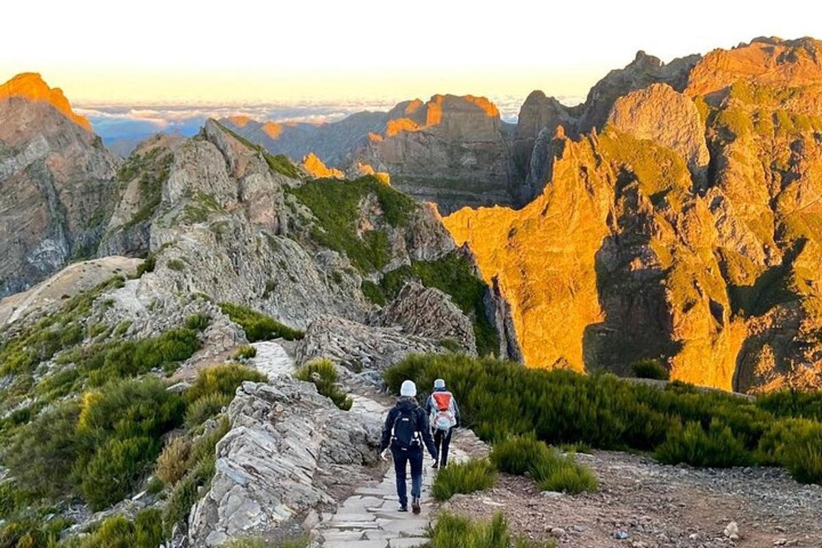 zwei Menschen gehen einen Pfad auf einem Berg hinunter