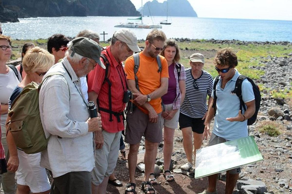 a group of people standing on a beach looking at a map