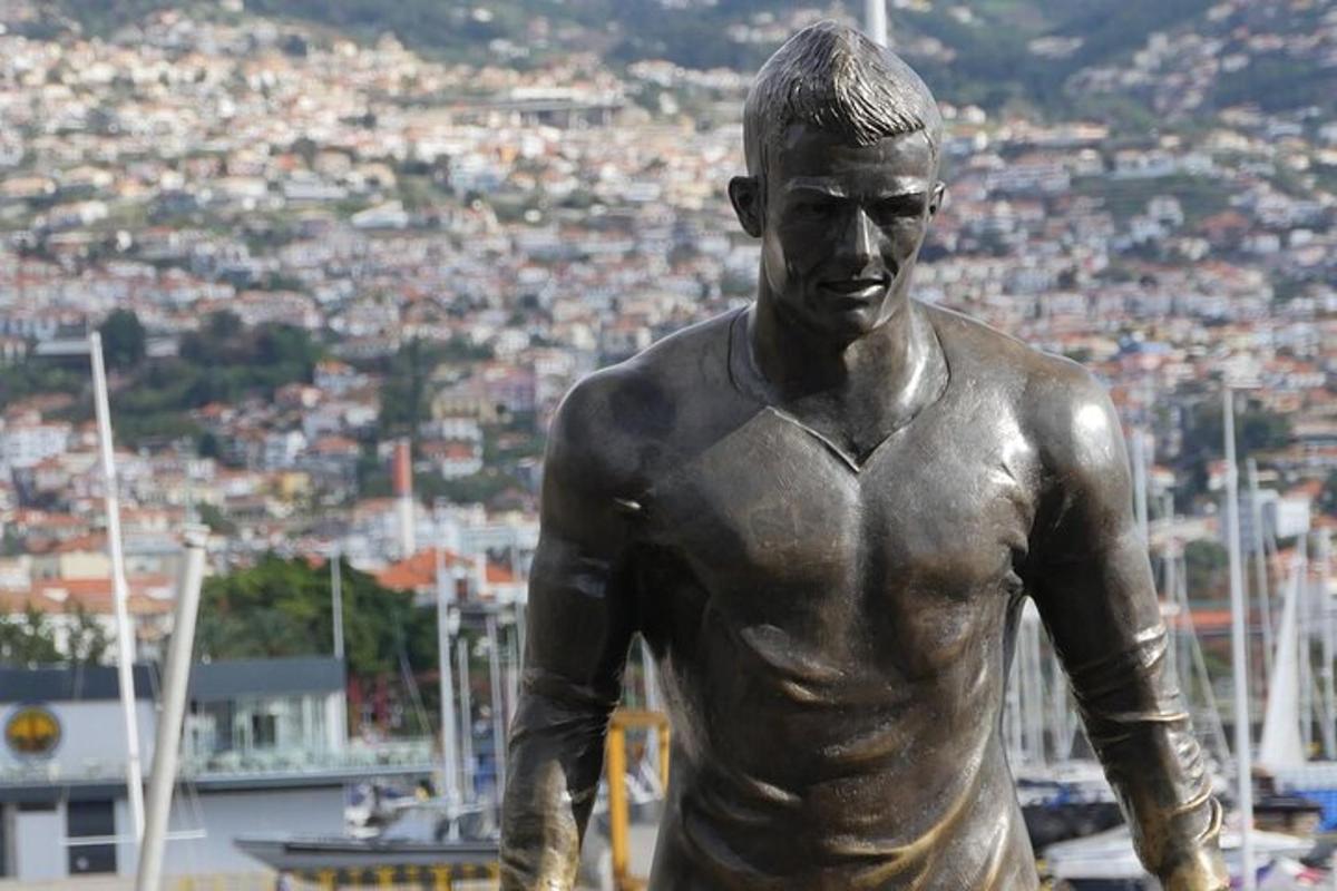 uma estátua de um homem em pé em frente a uma cidade