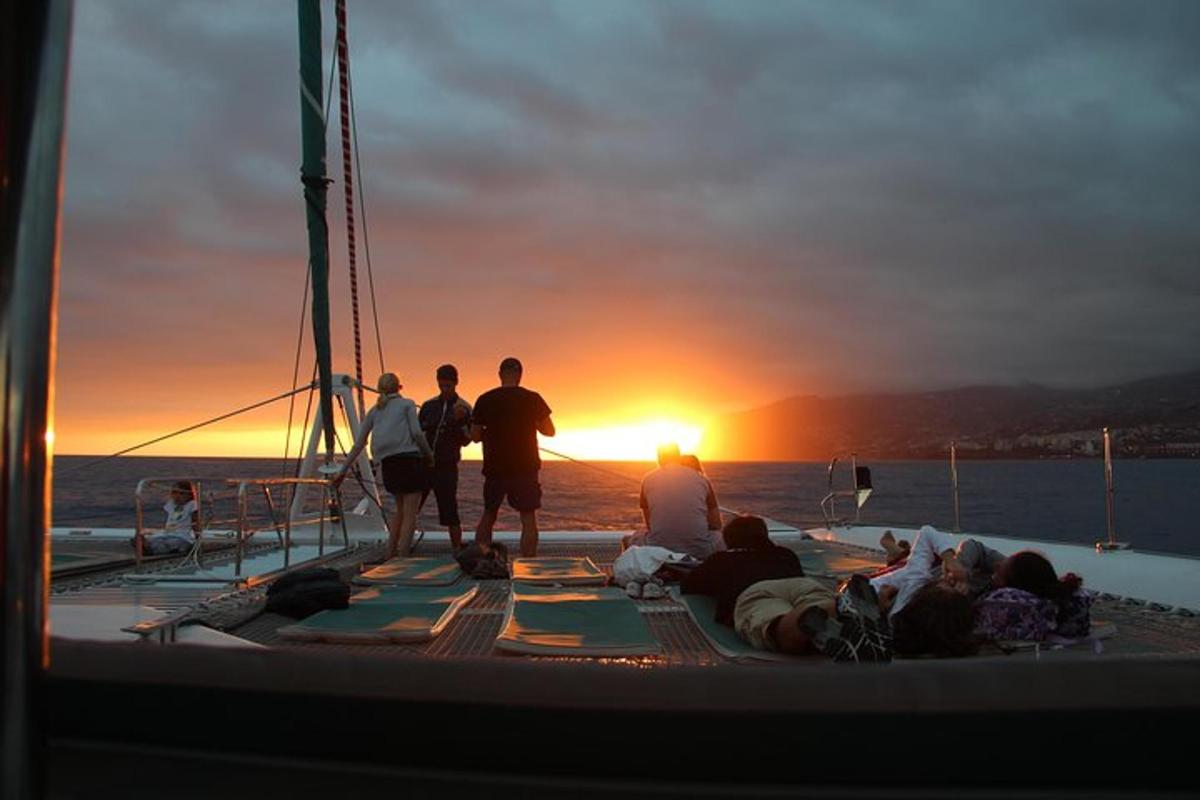un grupo de personas en un barco al atardecer