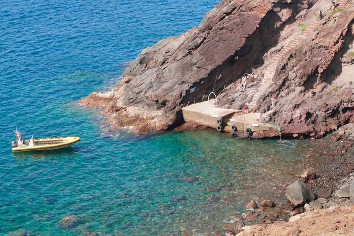 en båt i vannet ved siden av en klippe