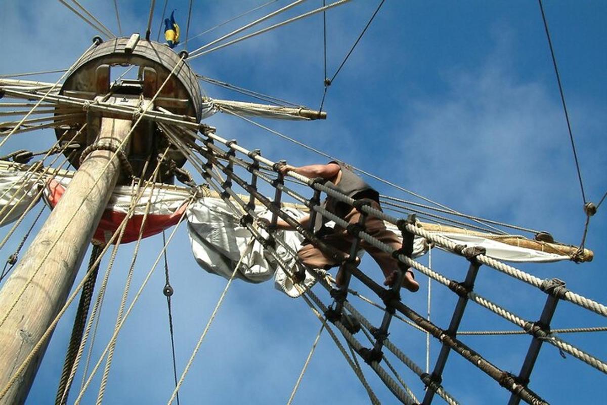 un uomo che si arrampica sul sartiame di una nave pirata