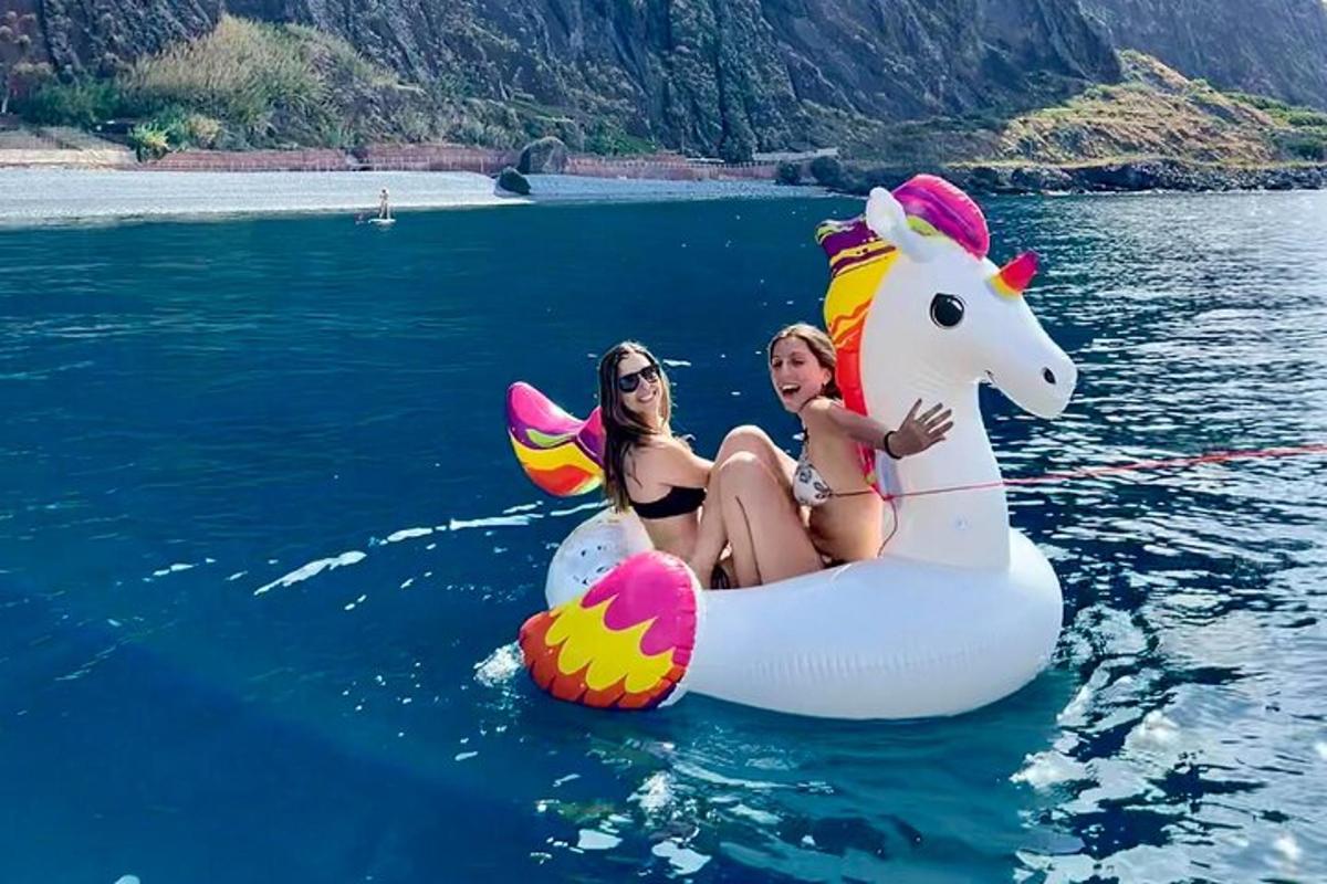 twee vrouwen zitten op een eenhoornvlot in het water