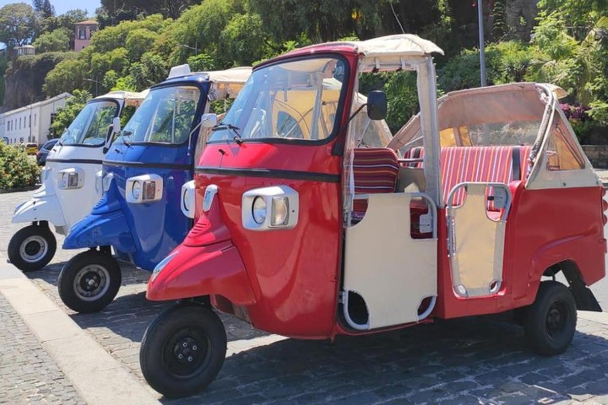 um grupo de três carrinhos de golfe estacionados em uma rua