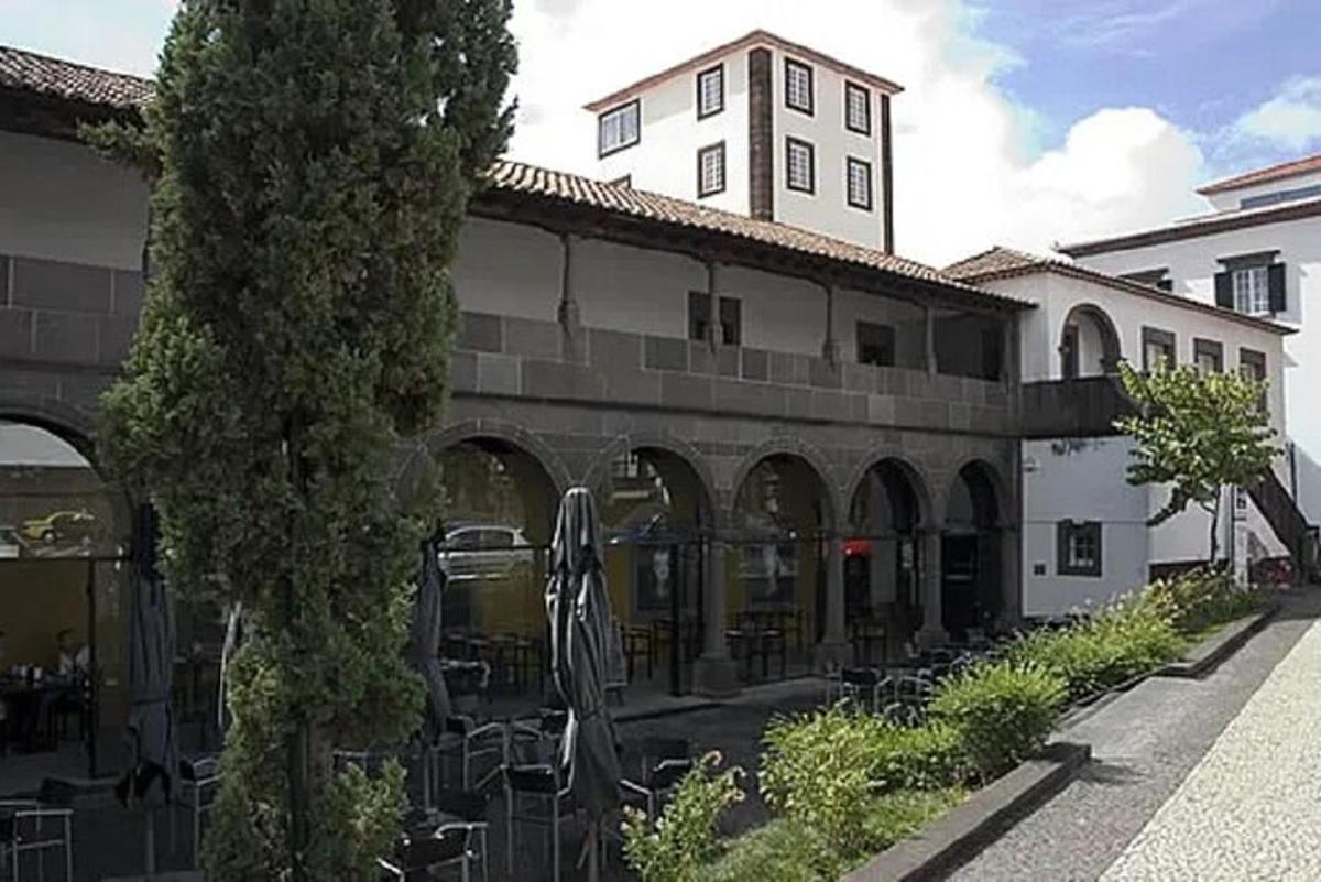 ένα κτίριο με ένα δέντρο μπροστά του