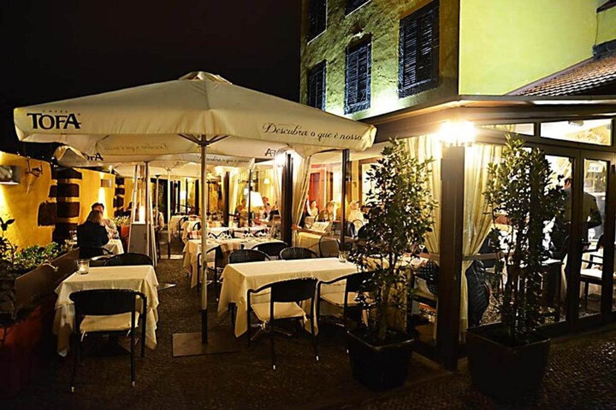 um restaurante com mesas e guarda-sóis à noite