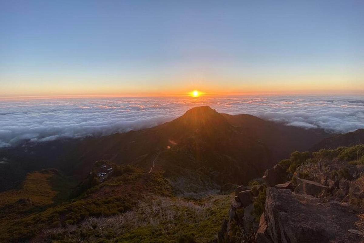un tramonto in cima a una montagna con nuvole