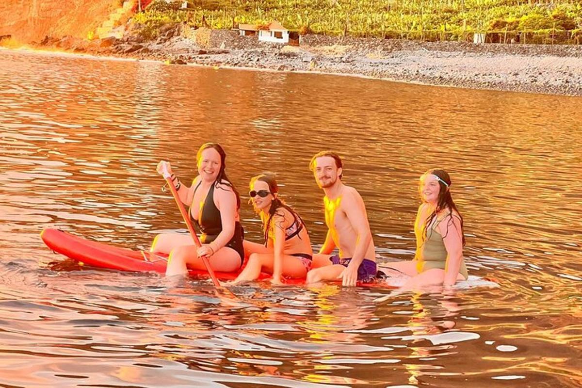 skupina lidí sedících na paddleboardu ve vodě