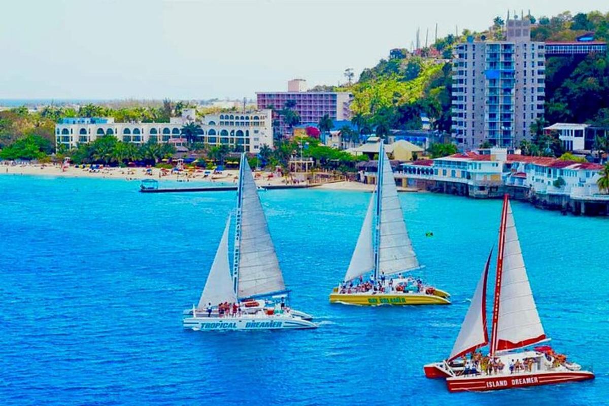 un gruppo di tre barche a vela in uno specchio d'acqua