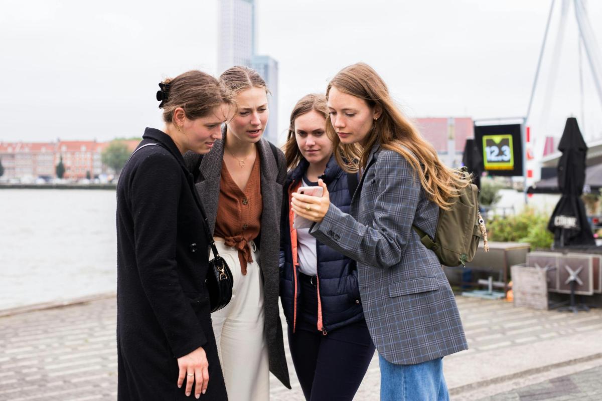 skupina žen dívajících se na mobilní telefon