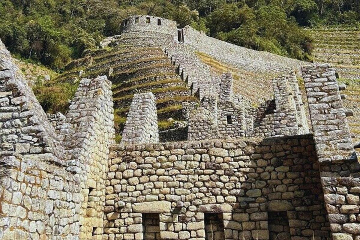 un grande edificio in pietra con scale su una collina