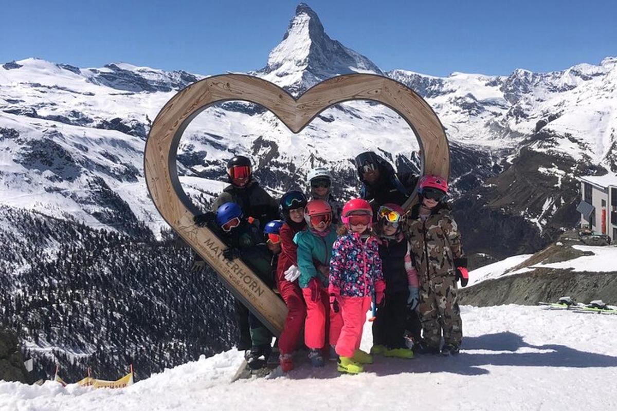 a group of children standing in front of a heart on a mountain