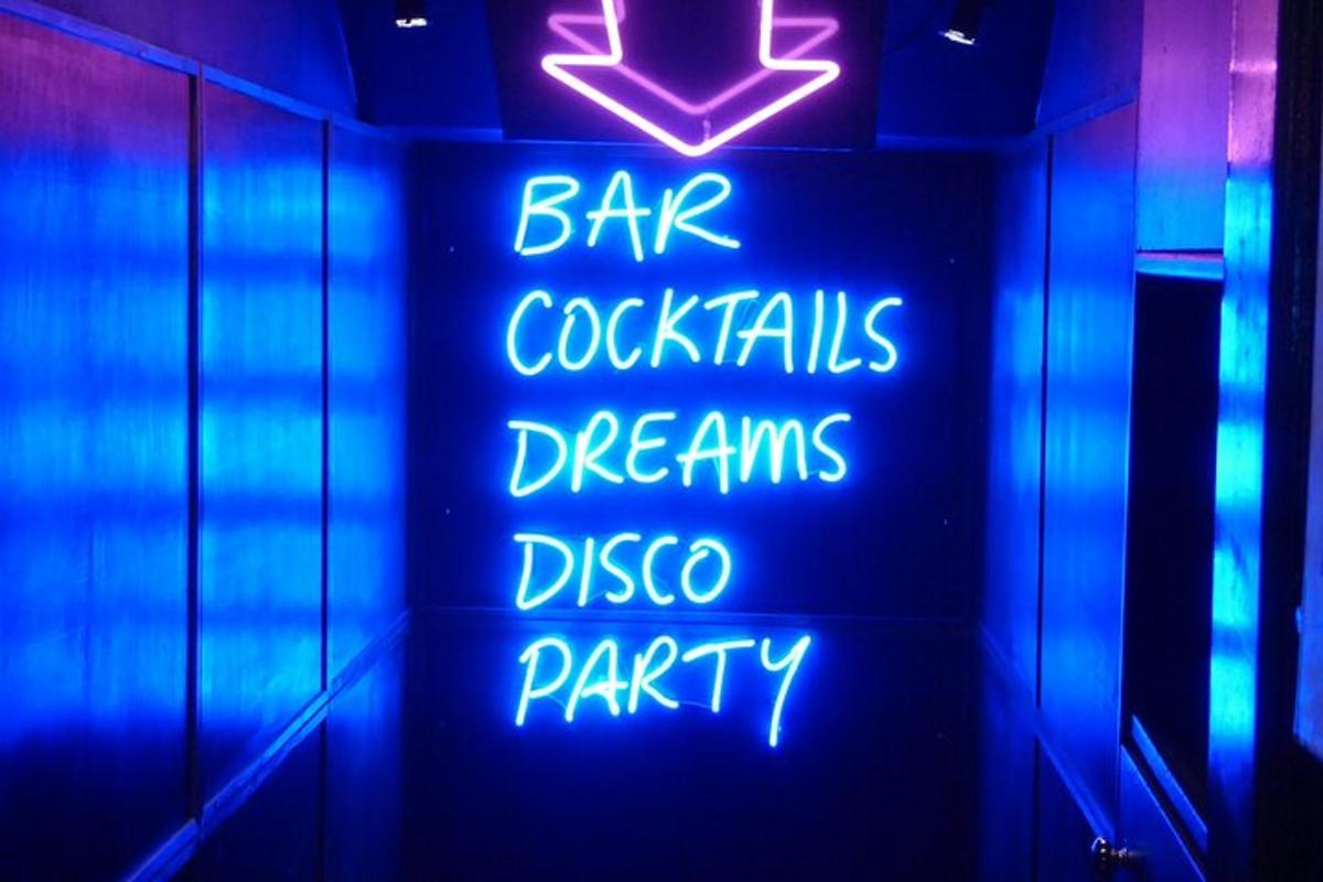 o firmă neon care spune cocktailuri de bar, vise, petrecere disco