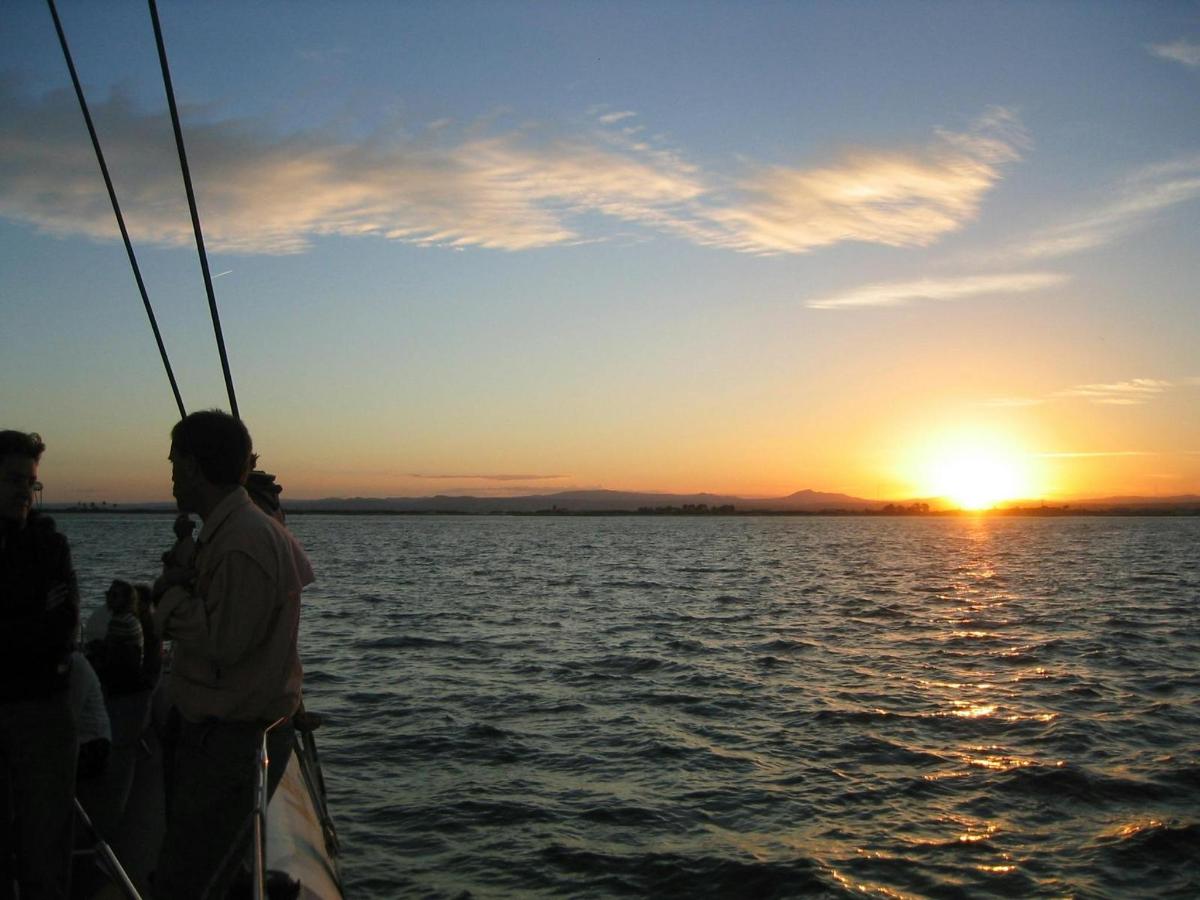 eine Gruppe von Menschen auf einem Boot bei Sonnenuntergang
