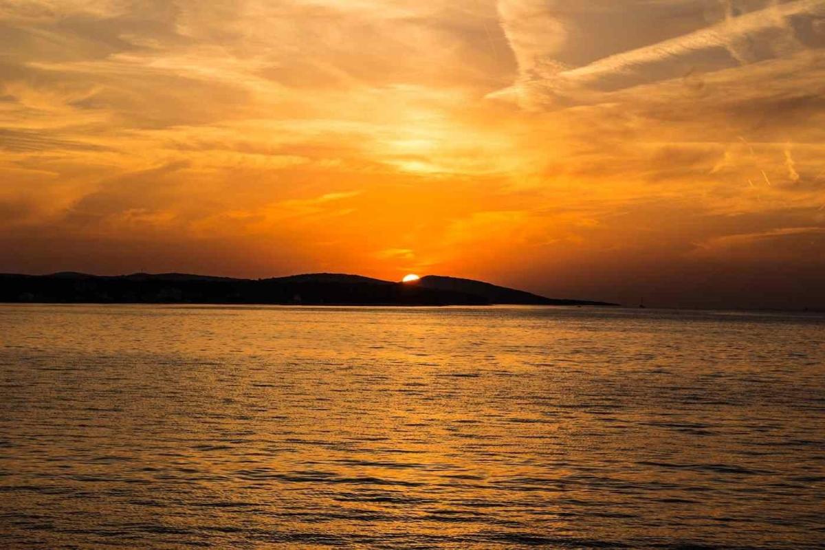 ein Sonnenuntergang über einem Gewässer mit untergehender Sonne