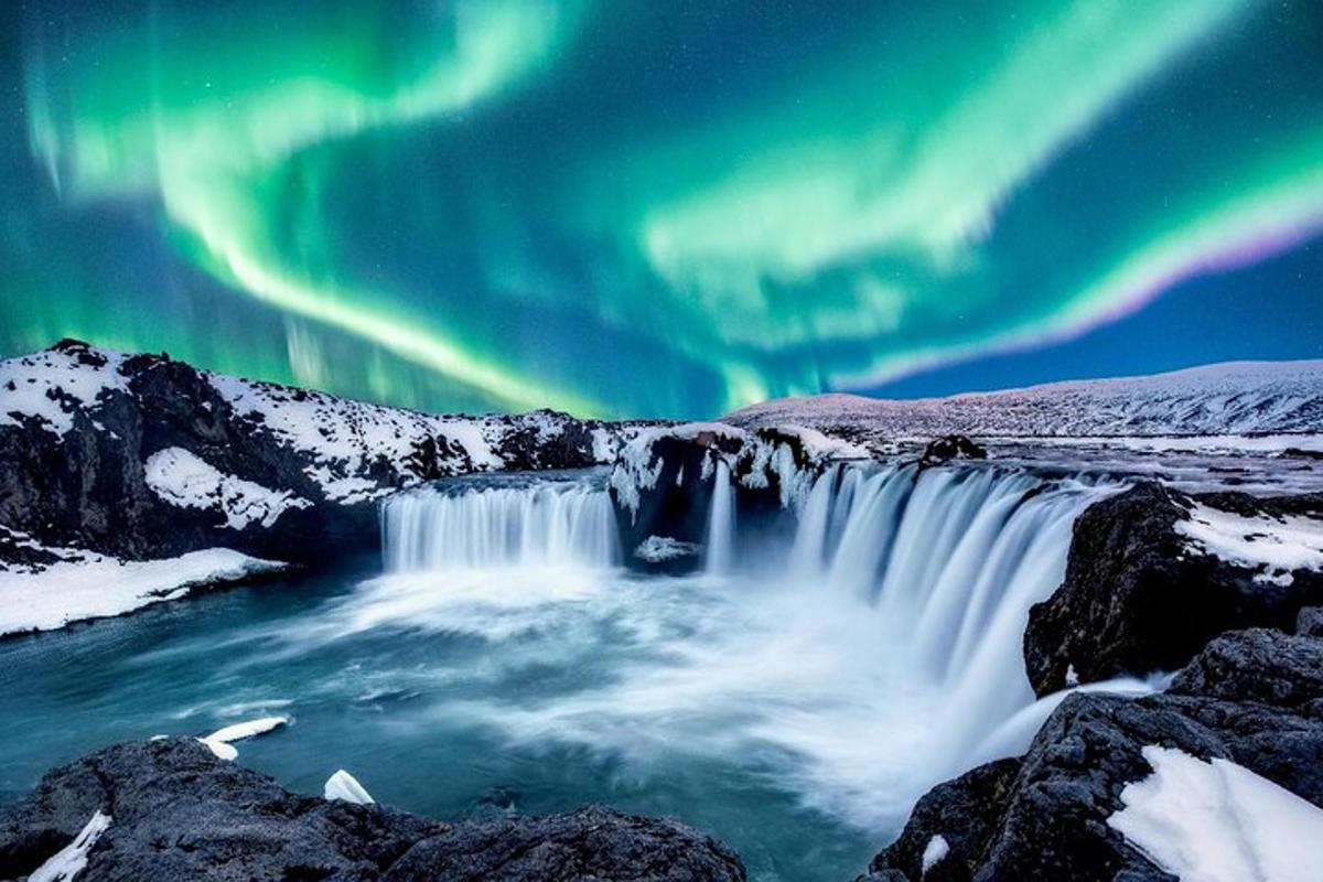 mynd af fossi undir norðurljósum
