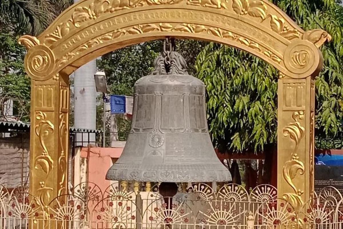 una gran campana penjada d'una porta daurada