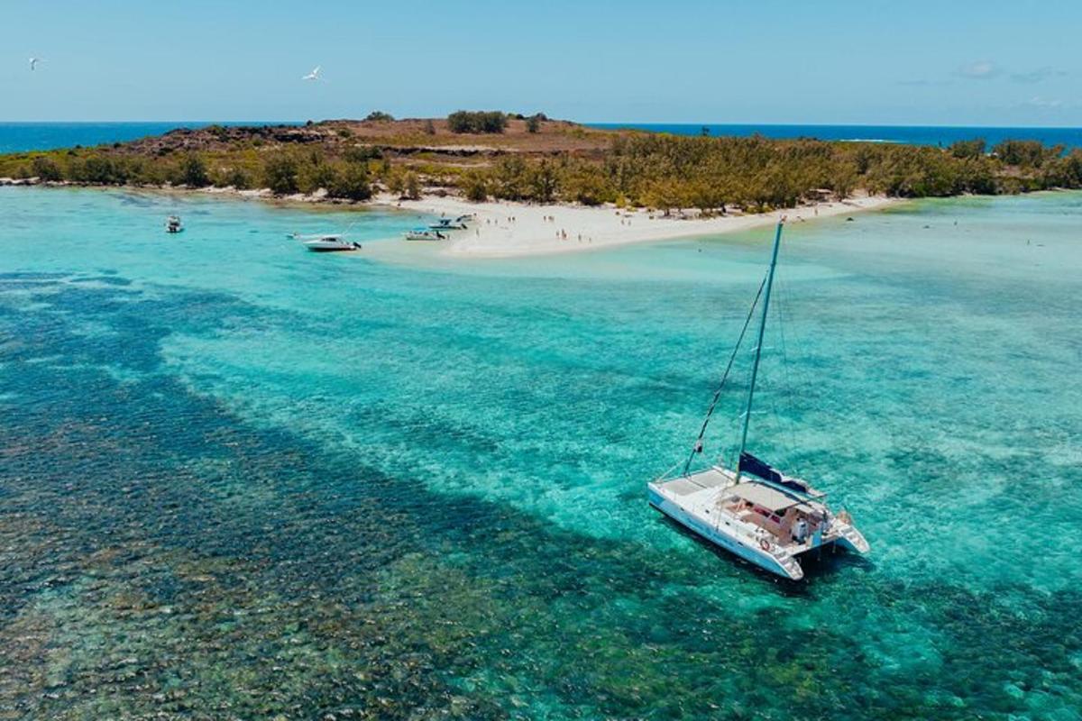 ein Segelboot im Wasser neben einer Insel